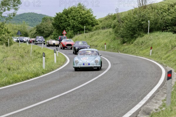 Blue vintage car leads a group of classic cars on a winding country road, picturesque surroundings, classic car, car race, Mille Miglia, 1000 Miglia, 2015, Tuscany, Rome Lake Garda, Italy