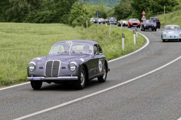 Grey vintage car with race number on a country road, nostalgic atmosphere and historic rally, vintage car, car race, Mille Miglia, 1000 Miglia, 2015, Tuscany, Rome Lake Garda, Italy