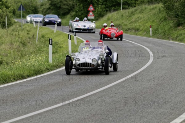 Silver racing car leads ahead of red classic car on winding country road, classic car, car race, Mille Miglia, 1000 Miglia, 2015, Tuscany, Rome Lake Garda, Italy