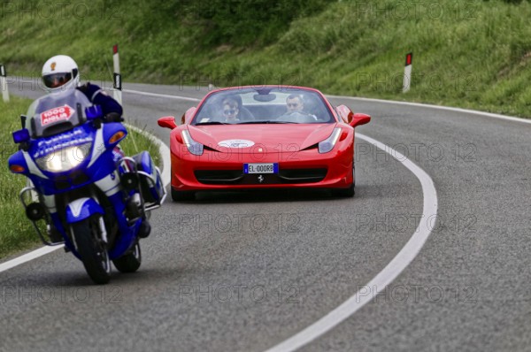 Blue motorbike overtakes red Ferrari convertible on winding road, classic car, car race, Mille Miglia, 1000 Miglia, 2015, Tuscany, Rome Lake Garda, Italy