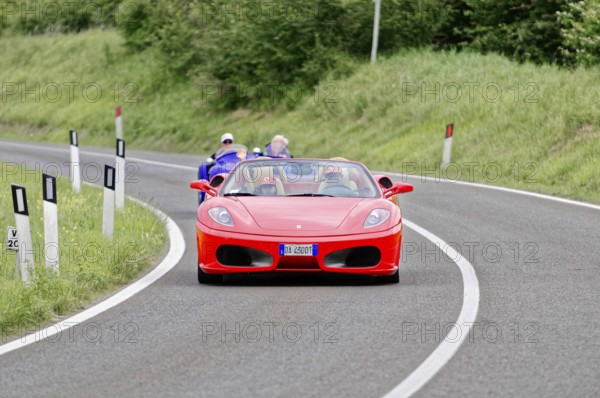 Red Ferrari convertible on winding road surrounded by green landscape, classic car, car race, Mille Miglia, 1000 Miglia, 2015, Tuscany, Rome Lake Garda, Italy