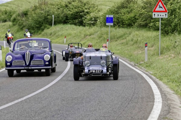 Purple vintage car and black car driving side by side on country road, vintage car, car race, Mille Miglia, 1000 Miglia, 2015, Tuscany, Rome Lake Garda, Italy