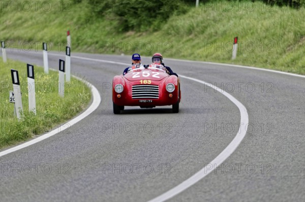 A red convertible sports car with two drivers on a winding country road, classic car, car racing, Mille Miglia, 1000 Miglia, 2015, Tuscany, Rome Lake Garda, Italy