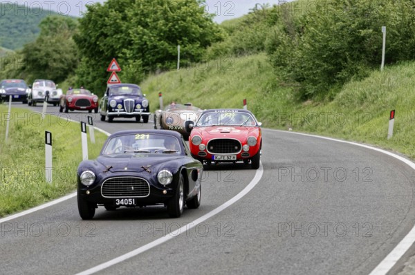 Black classic car followed by red and other classic cars on a winding road, dynamic race, classic car, car race, Mille Miglia, 1000 Miglia, 2015, Tuscany, Rome Lake Garda, Italy