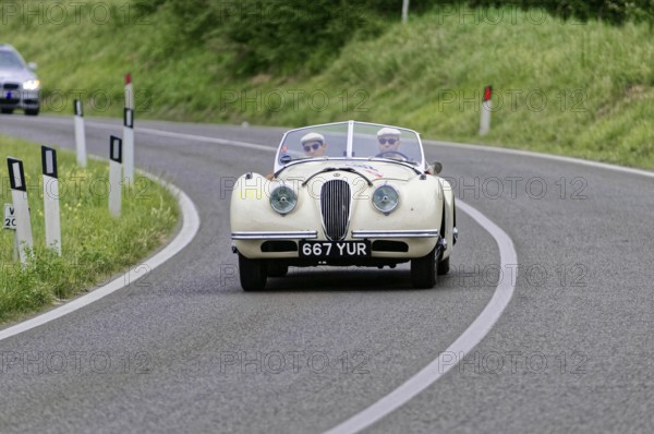 White vintage convertible on a winding country road surrounded by nature, vintage car, car racing, Mille Miglia, 1000 Miglia, 2015, Tuscany, Rome Lake Garda, Italy
