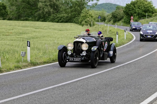 A classic vintage car with two drivers takes part in a car rally on a picturesque road, classic car, car race, Mille Miglia, 1000 Miglia, 2015, Tuscany, Rome Lake Garda, Italy