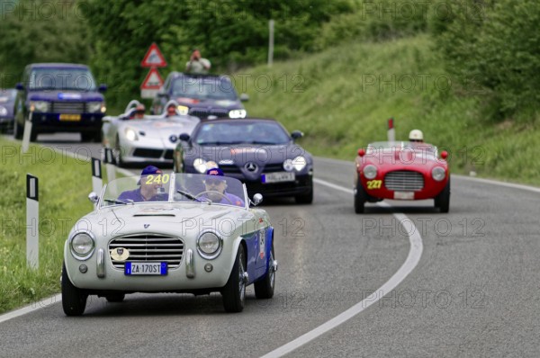 Classic car driving on a winding country road in the middle of a green landscape at a car rally, classic car, car race, Mille Miglia, 1000 Miglia, 2015, Tuscany, Rome Lake Garda, Italy