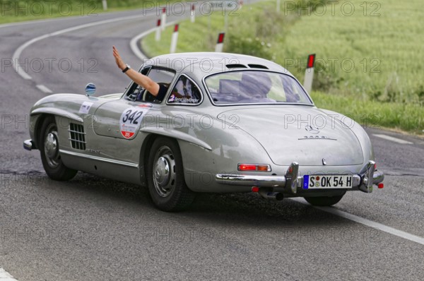 Silver retro sports car turns off on a winding road, classic car, car racing, Mille Miglia, 1000 Miglia, 2015, Tuscany, Rome Lake Garda, Italy
