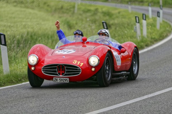 Two people driving in a red Maserati classic car on a winding country road, classic car, car racing, Mille Miglia, 1000 Miglia, 2015, Tuscany, Rome Lake Garda, Italy