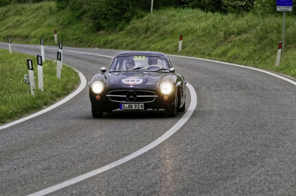 Black classic car drives through a picturesque winding road, classic car, car race, Mille Miglia, 1000 Miglia, 2015, Tuscany, Rome Lake Garda, Italy