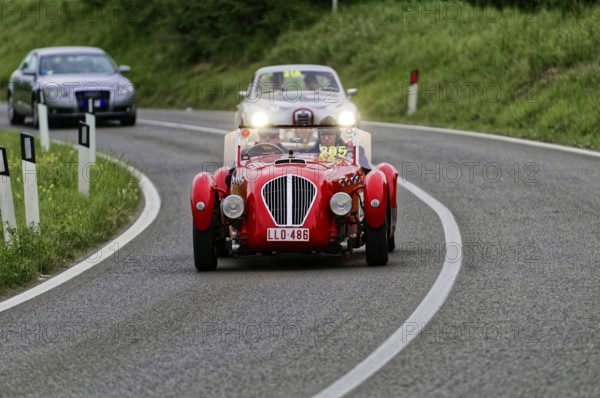 Red classic car on a winding country road at dusk, classic car, car race, Mille Miglia, 1000 Miglia, 2015, Tuscany, Rome Lake Garda, Italy