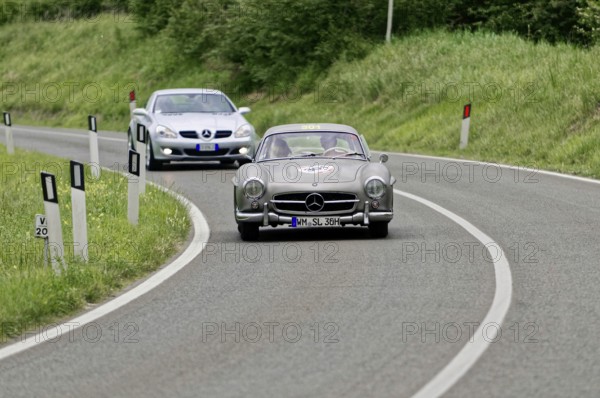 Two classic Mercedes cars driving on a winding country road in a green environment, classic car, car racing, Mille Miglia, 1000 Miglia, 2015, Tuscany, Rome Lake Garda, Italy