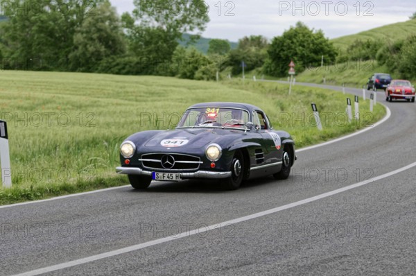 A black Mercedes classic car drives stylishly through the green landscape, classic car, car race, Mille Miglia, 1000 Miglia, 2015, Tuscany, Rome Lake Garda, Italy