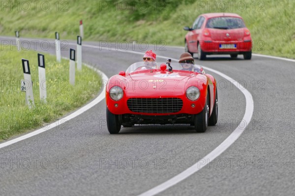 Red Ferrari vintage convertible on a winding country road during a race, vintage car, car race, Mille Miglia, 1000 Miglia, 2015, Tuscany, Rome Lake Garda, Italy