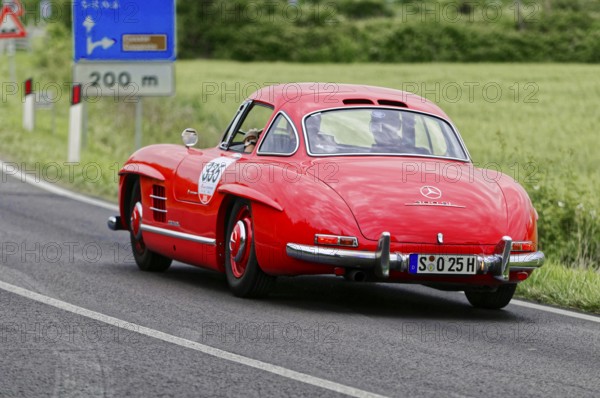 A red Mercedes classic car is seen from behind on a country road, classic car, car race, Mille Miglia, 1000 Miglia, 2015, Tuscany, Rome Lake Garda, Italy