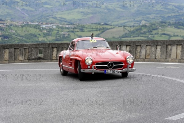 No. 334, Mercedes-Benz 300 SL W 198, year of construction 1955, Red classic sports car in curve with mountain panorama in the background, Mille Miglia 2014 or 1000 Miglia, classic car race, San Marino, Italy