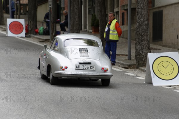 No. 269, Porsche 356 1500, model year 1953, Silver car drives past targets with large signs, a person watches at the side of the road, Mille Miglia 2014 or 1000 Miglia, classic car race, San Marino, Italy