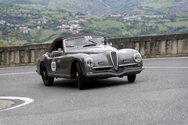 No. 153, Alfa Romeo 6C2500 SS cabriolet Pinin Farina, year of construction 1947, Silver classic cabriolet drives through a bend with green hilly landscape in the background, Mille Miglia 2014 or 1000 Miglia, classic car race, San Marino, Italy