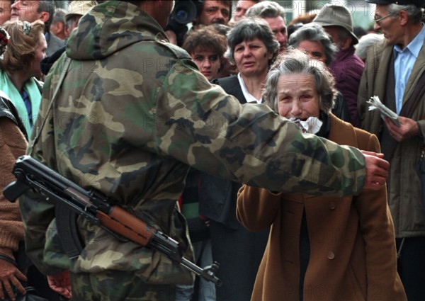 BIH, Bosnia, Sarajevo, 16.09.1992, woman is held back by a bus evacuating people from Sarajevo