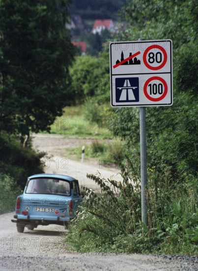 DEU, Eisenach, 01.07.1990 -- A satellite on a road outside Eisenach. -- Road with Trabbi in East Germany.