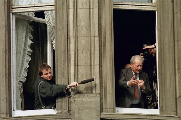 DEU, Erfurt, 01.07.1990 -- A radio reporter tries to get an original sound during Willy Brandt's speech in Erfurt. -- Reporters working during Willy Brandt's speech from the balcony in Erfurt.