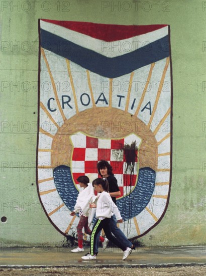 HRV, Split, 01.10.1991 -- Passers-by walk past the Croatian national coat of arms at an underpass in Split. -- Citizens passing the newly painted Croatian National Emblem at a wall in downtown Split. Eastern Europe, Eastern Europe, Balkans, Croatia
