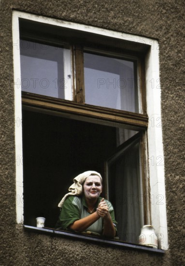 Berlin, DEU, 18.10.1999 -- A woman wearing a beauty mask (yogurt on face, face cream) looks out a window in Berlin-Kreuzberg.