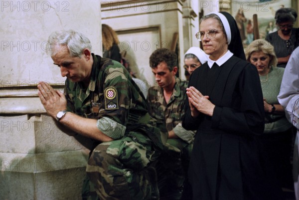 BIH, Sarajevo, 01.09.1995 -- A Bosnian soldier prays together with a Catholic nun during a service in Sarajevo. -- Bosnian soldiers and a catholic now pray during a Sunday mess in Sarajevo. Bosnia Hercogovina, Eastern Europe