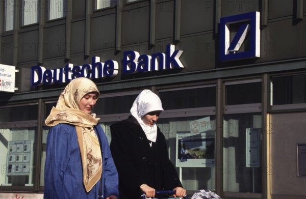 Berlin, DEU, 18.10.1998 -- Street scene in Neukölln - foreign woman with strollers pass through a bank.