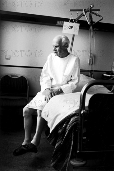 Berlin, DEU, 17.05.1998 -- ENT department, a patient (82 years old) sits on his hospital bed with an OP sign. (hospital, operation)