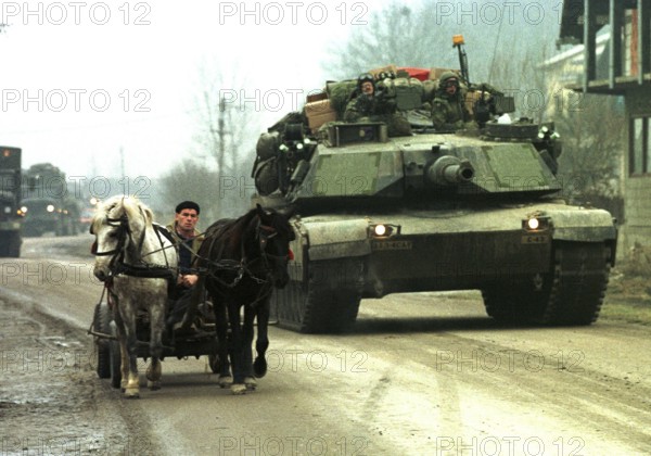 BIH, Tuzla, 01.01.1996 -- An American Abraham tank overtakes a Bosnian carriage near Tuzla. -- American Abraham tanks passing a horse-drawn carriage near their base at Tula airport. Bosnia Hercogovina, Eastern Europe
