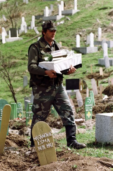 BIH, Bosnia, Tuzla, 07.05.1993 A Bosnian soldier is burying a child's coffin. The toddler was crushed in an overcrowded truck while fleeing from Srebrenica