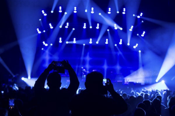 Two concertgoers photograph Sting (civil: Gordon Matthew Thomas Sumner, CBE) live with their mobile phones on a Sting 3.0 tour in Berlin's Uber Arena on 16.10.2025
