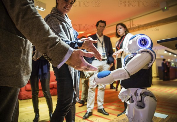 ITA Italy Castelfalfi participants greet a robot during a conference for tourism managers