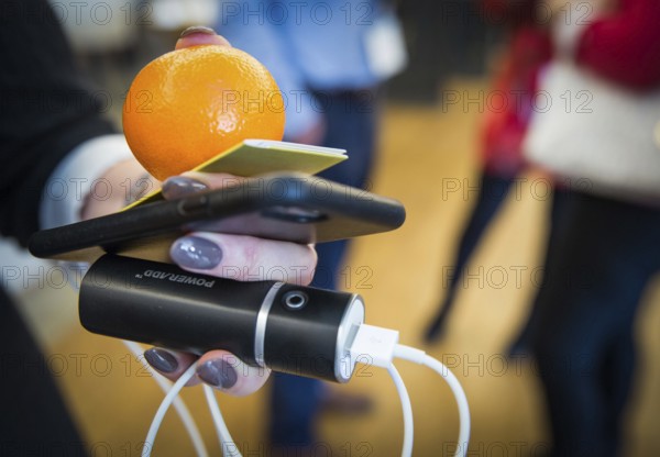 ITA Italy Castelfalfi A participant during a conference for tourism managers with smartphone, power bank and orange