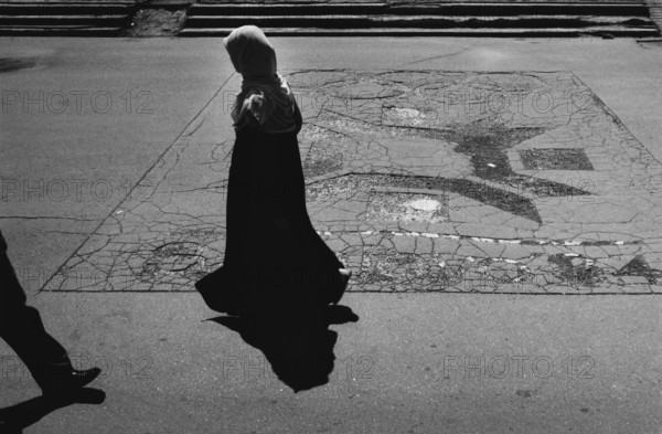 BIH, Bosnia, Sarajevo, 22.07.2005, People walk past the Olympic emblem of the 1984 Winter Games