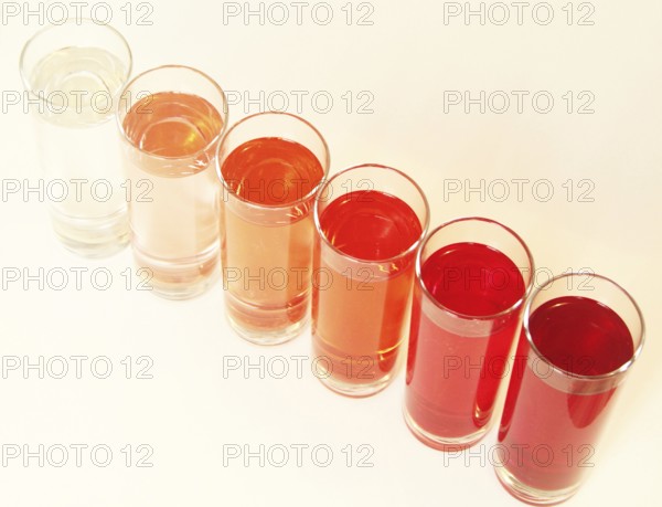 Five glasses of red liquid on white background, São Paulo, Brazil