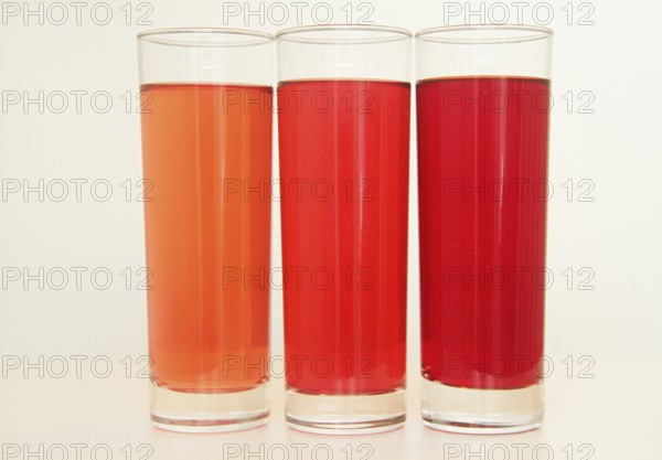 Three glasses of red and transparent liquid on white background, São Paulo, Brazil
