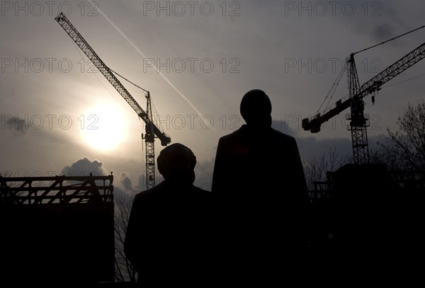 The statues of Marx and Engels stand against cranes demolishing the Palace of the Republic Politicians Communism Socialism State Building Architecture Construction Industry City Planning City Center Landmark Berlin Mitte East Berlin GDR Icons