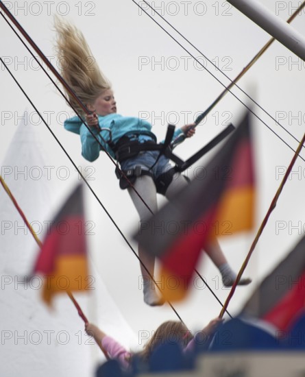 DEU Germany Berlin girls jumping on trampolines. Scene on the eve of the 20th anniversary of German reunification on the festival mile in Berlin. Germany Berlin Girl Is Dong Trampoline Jumping Scene from the Public Party One Day Ahead of the Celebration Marking the 20th Anniversary of the German Reunification