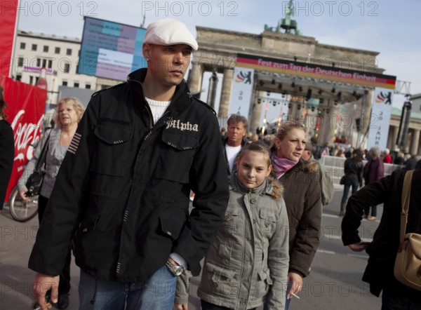 DEU Germany Berlin People stroll in front of the Brandenburg Gate. Scene on the eve of the 20th anniversary of German reunification on the festival mile in Berlin. Germany Berlin People Promenade in front of Brandenburg Gate. Scene from the public party one day ahead of the celebration marking the 20th anniversary of the German reunification