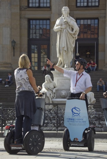 GERMANY Berlin Segway drivers during a guided city tour in front of the Schiller Monument on the Gendarmenmarkt. Germany Berlin Segway driver during a visit to the Gendarmenmarkt in front of a statue of German author Schiller