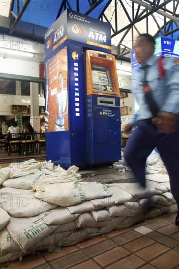 A man in uniform passes by an ATM that has been protected against the floods of Chao Praya with filled sandbags. The river, which flows through the Thai capital Bangkok, regularly floods the waterfront. Severe Weather Water Disasters Protection Flood Money ATM Machine Electronics