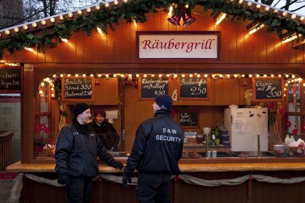Berlin 2010-11-24 Security guards in front of the snack bar at a Christmas market. DEU Berlin 2010-11-24 Security personnel at a Chistmas Market in downtown Berlin