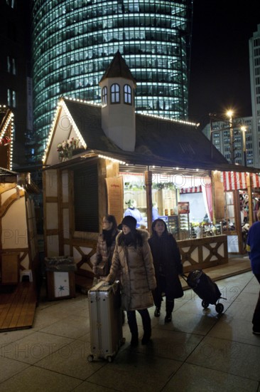 Berlin 2010-11-24 tourists with suitcases at the Christmas market at Potsdamer Platz DEU Berlin 2010-11-24 Asian tourists cross the Christmas market at Potsdamer Platz