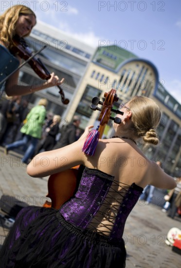 GERMANY Berlin Street musicians in corsets play violin and cello at Hackescher Markt. Germany Berlin Street musicians playing violin and cello at a famous spot Hackescher Markt