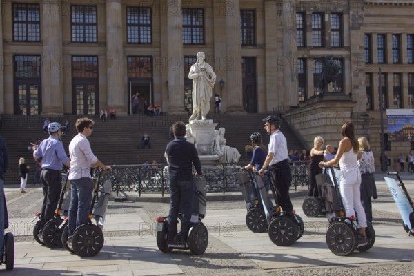 GERMANY Berlin Segway drivers during a guided city tour in front of the Schiller Monument on the Gendarmenmarkt. Germany Berlin Segway driver during a visit to the Gendarmenmarkt in front of a statue of German author Schiller
