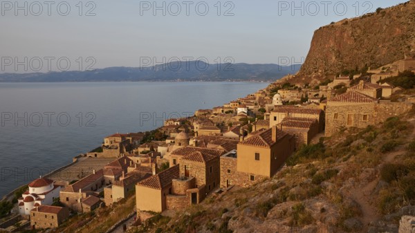 Soft morning light, medieval coastal town at sunrise with sea view and tiled roofs, Monemvasia, Monemvassia, Malvasy, small Byzantine town, rocky island, fortress, Laconia, Peloponnese, peninsula, Greece