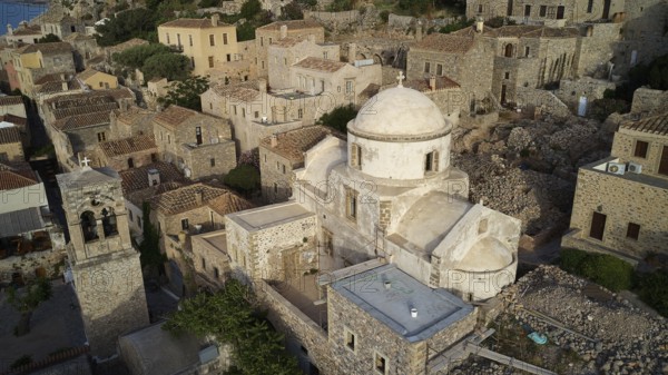 Drone view, aerial view of churches and stone houses in traditional village with vegetation, Monemvasia, Monemvassia, Malvasy, small Byzantine town, rocky island, fortress, Laconia, Peloponnese, peninsula, Greece