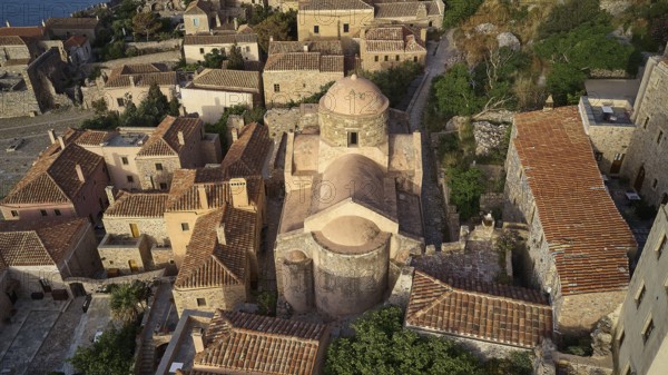 Drone view, aerial view of a compact church structure with domed roof, surrounded by traditional houses, Monemvasia, Monemvassia, Malvasy, Byzantine small town, rocky island, fortress, Laconia, Peloponnese, peninsula, Greece